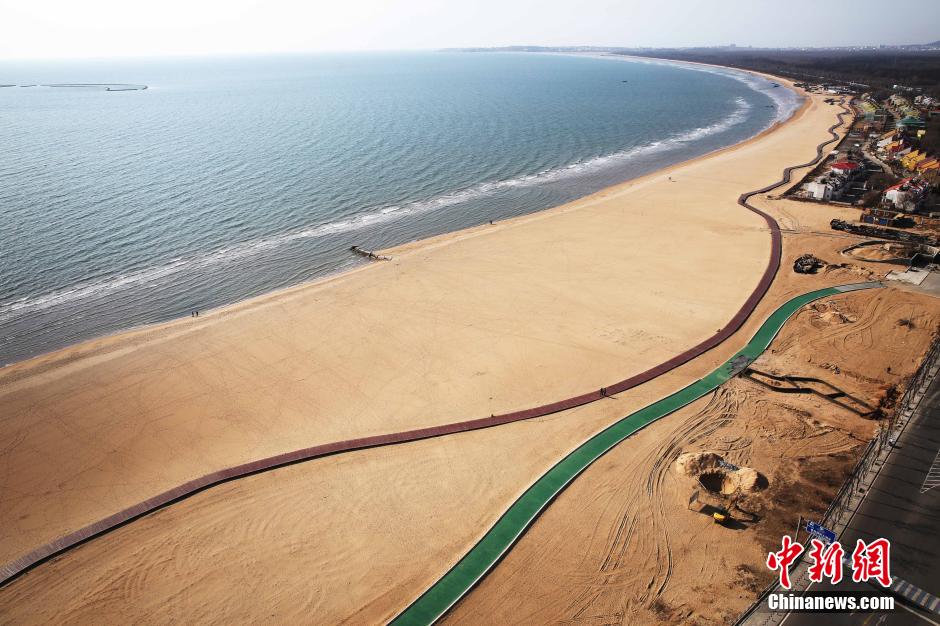3月13日，秦皇島萬(wàn)米臨海沙灘木棧道。據(jù)了解，該木棧道全長(zhǎng)約4200米，與北戴河區(qū)原有的7500米木棧道對(duì)接后全線總長(zhǎng)度1.17萬(wàn)米，整個(gè)木棧道東起秦皇島體育基地游船碼頭，西至北戴河濕地公園，呈波浪形蜿蜒10.4公里海岸線。 中新社發(fā) 曹建雄 攝 CNSPHOTO