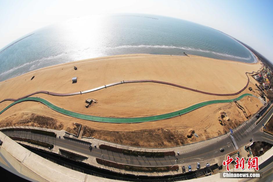 3月13日，秦皇島萬(wàn)米臨海沙灘木棧道。據(jù)了解，該木棧道全長(zhǎng)約4200米，與北戴河區(qū)原有的7500米木棧道對(duì)接后全線總長(zhǎng)度1.17萬(wàn)米，整個(gè)木棧道東起秦皇島體育基地游船碼頭，西至北戴河濕地公園，呈波浪形蜿蜒10.4公里海岸線。 中新社發(fā) 曹建雄 攝 CNSPHOTO